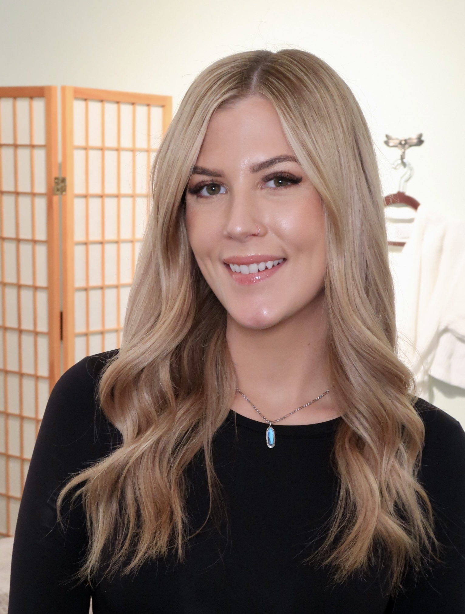 A woman with long blonde hair wearing black.