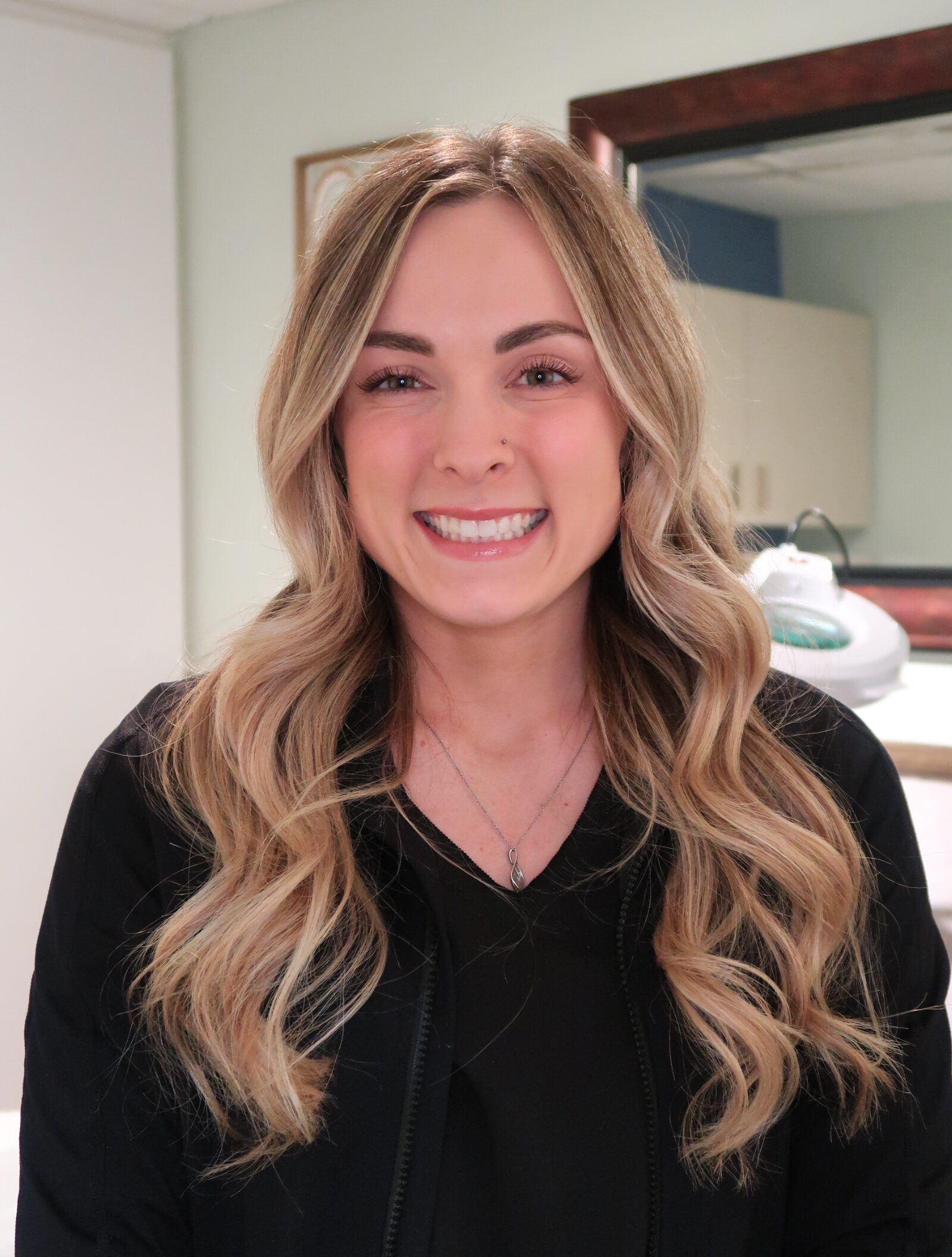 A woman with long blonde hair smiles for the camera.