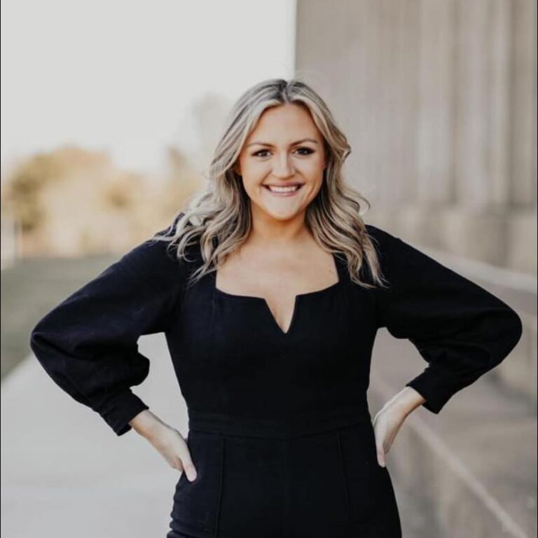 A woman in black dress standing on steps.