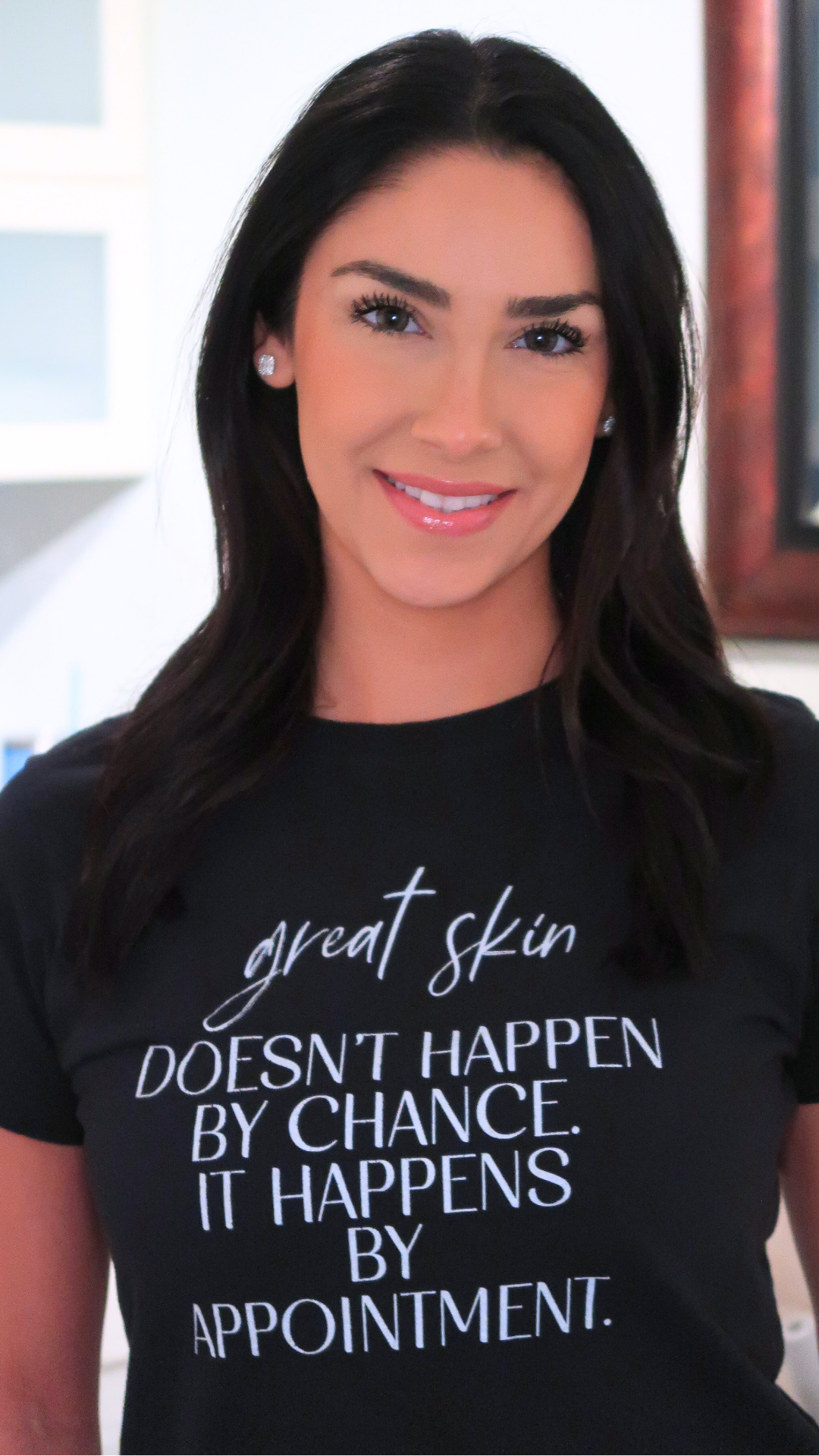 A woman wearing a black shirt with the words " great skin doesn 't happen by chance ".